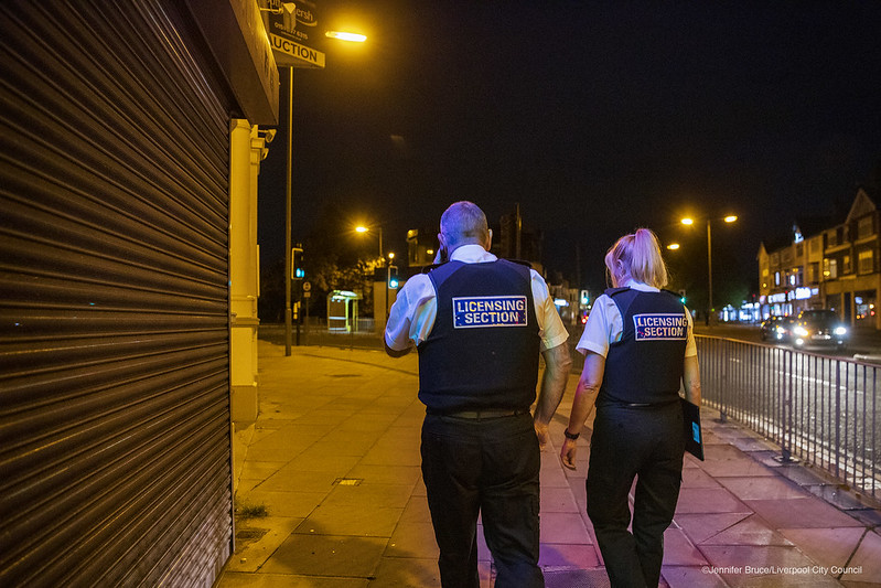 Two licensing officers working at night, liaising with licensees.