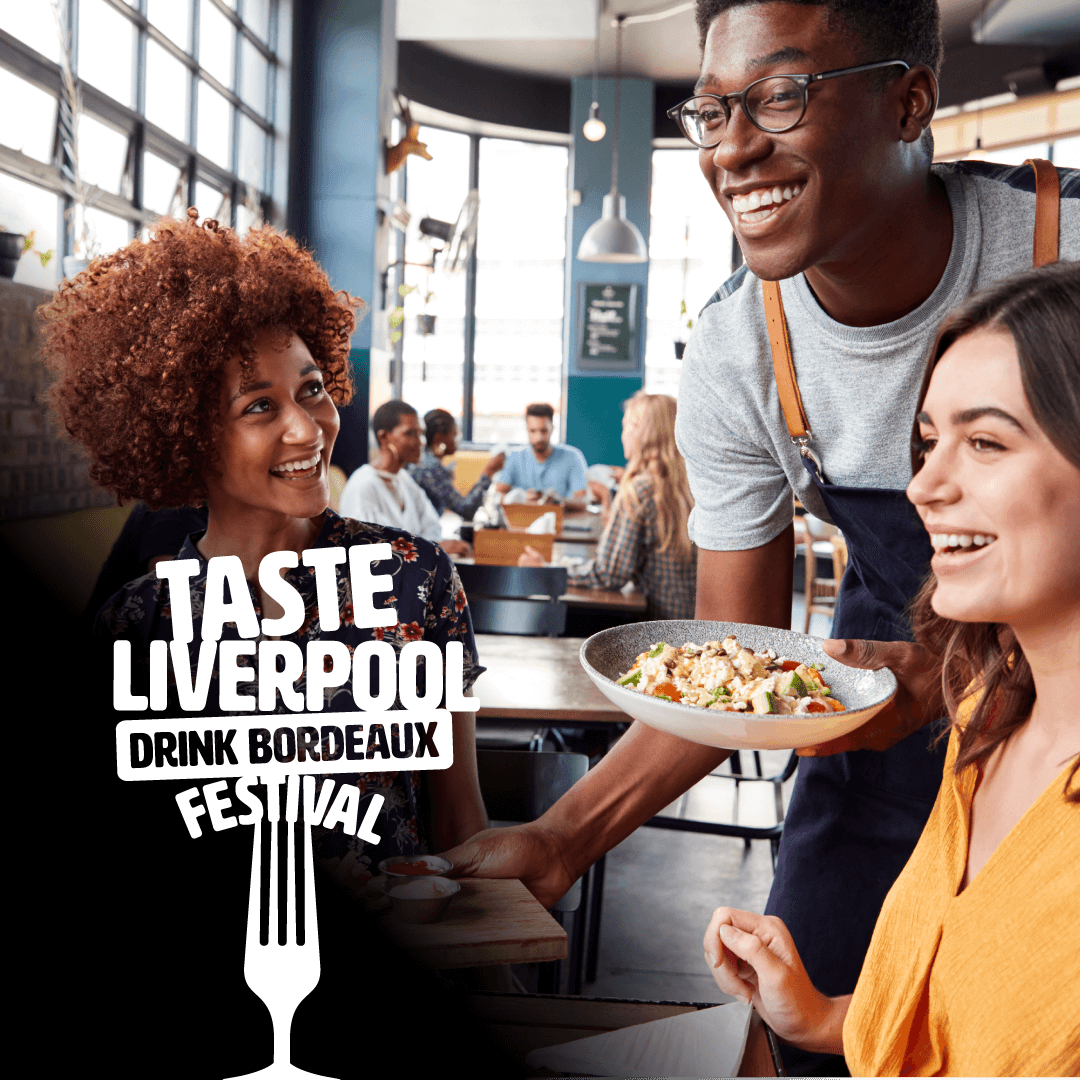 Two females being served food by a male waiter