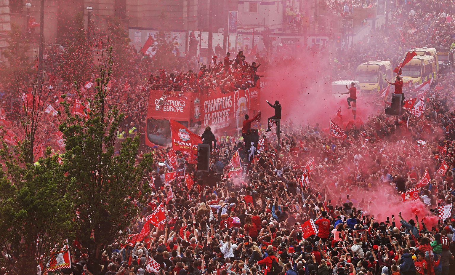 LFC fans line homecoming parade route on The Strand with the LFC 'Champions of Europe' bus in the centre. It's a sea of red.