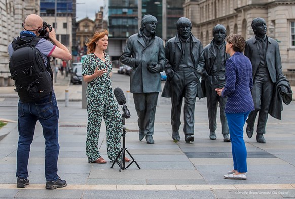 Claire McColgan being interviewed by the media in front of The Beatles statue