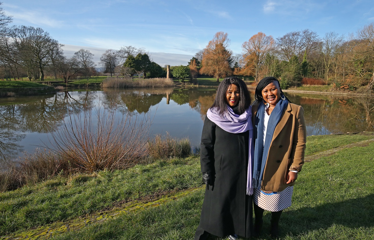 Dr Maki and Tukwini Mandela stood in front of the lake at Princes Park