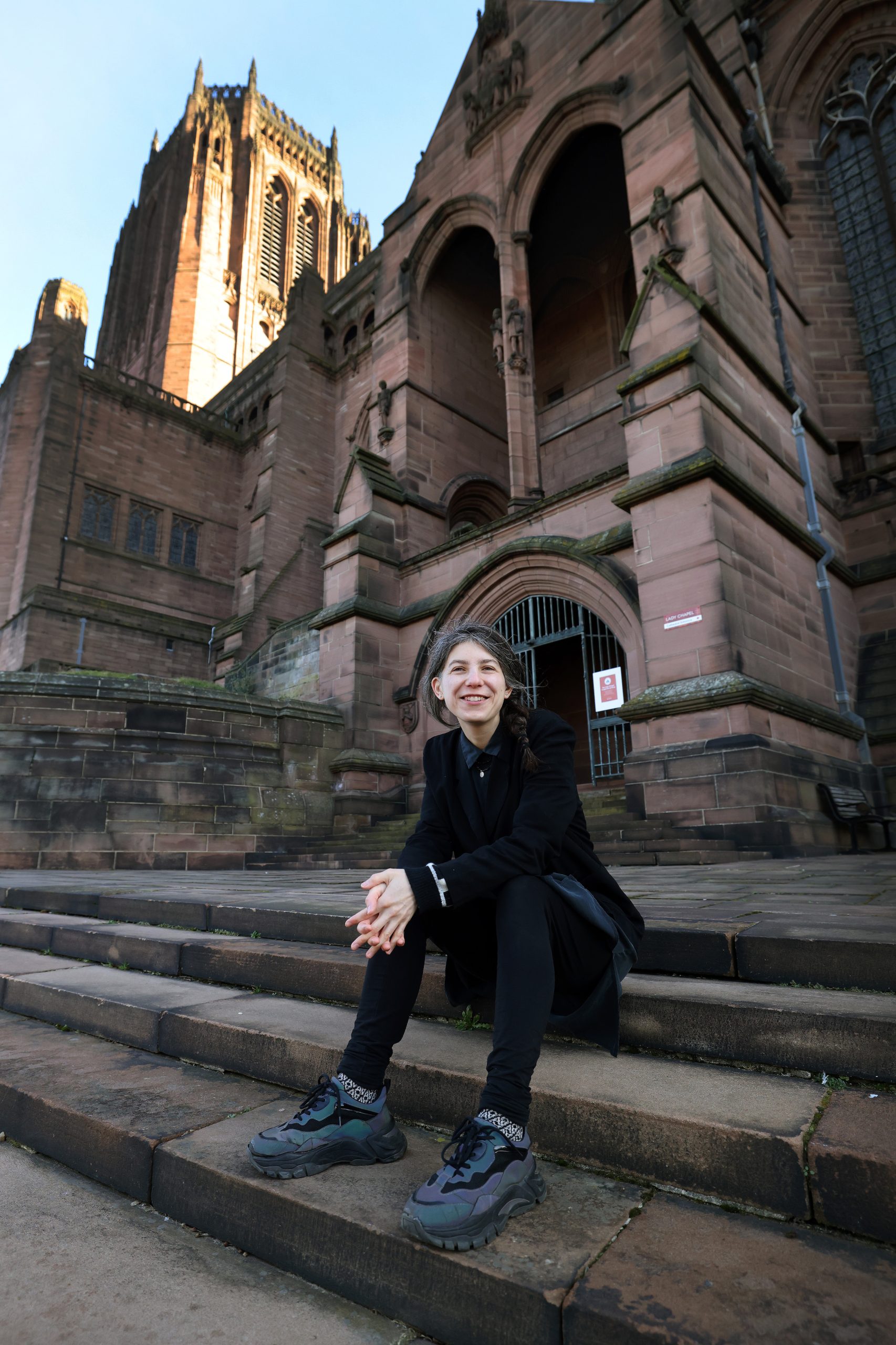 Woman sat on steps of cathedral