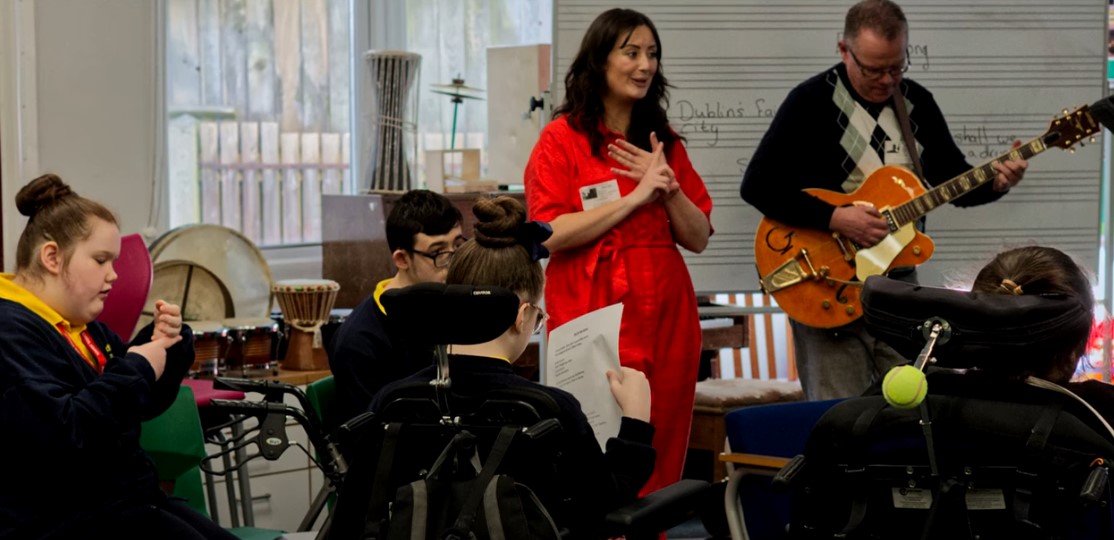 Adults and children singing and playing instruments