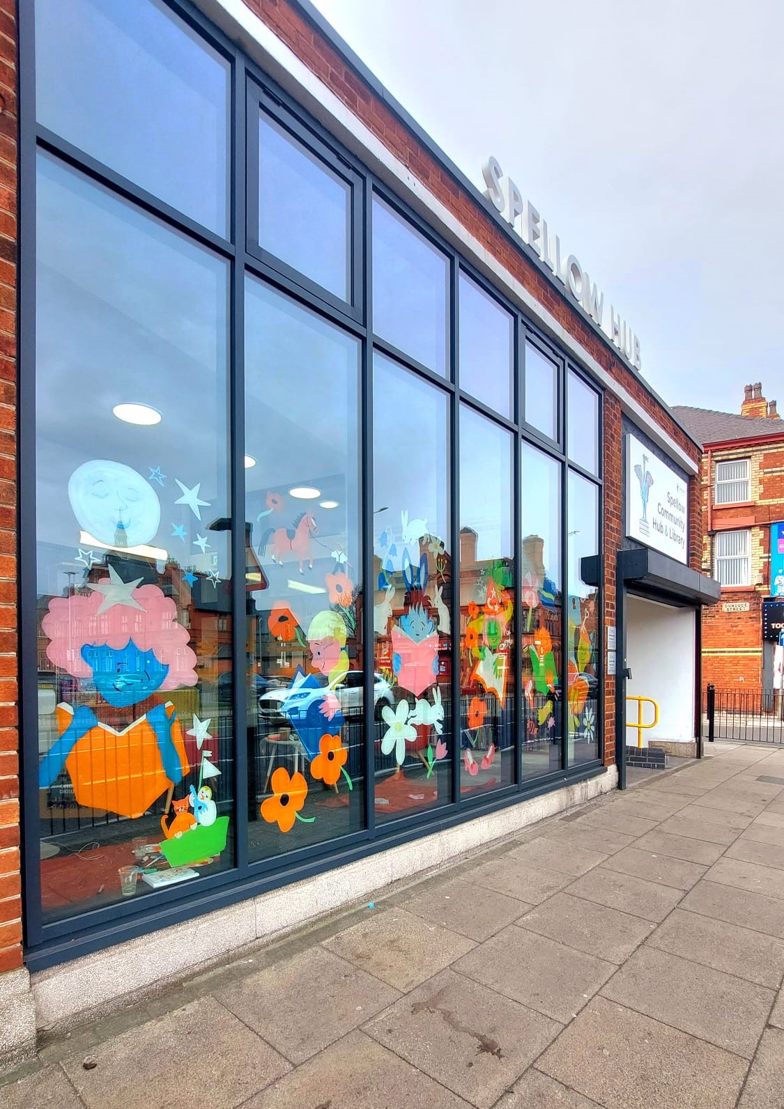 An illustrated window on a library. The illustrations depict children's fiction.
