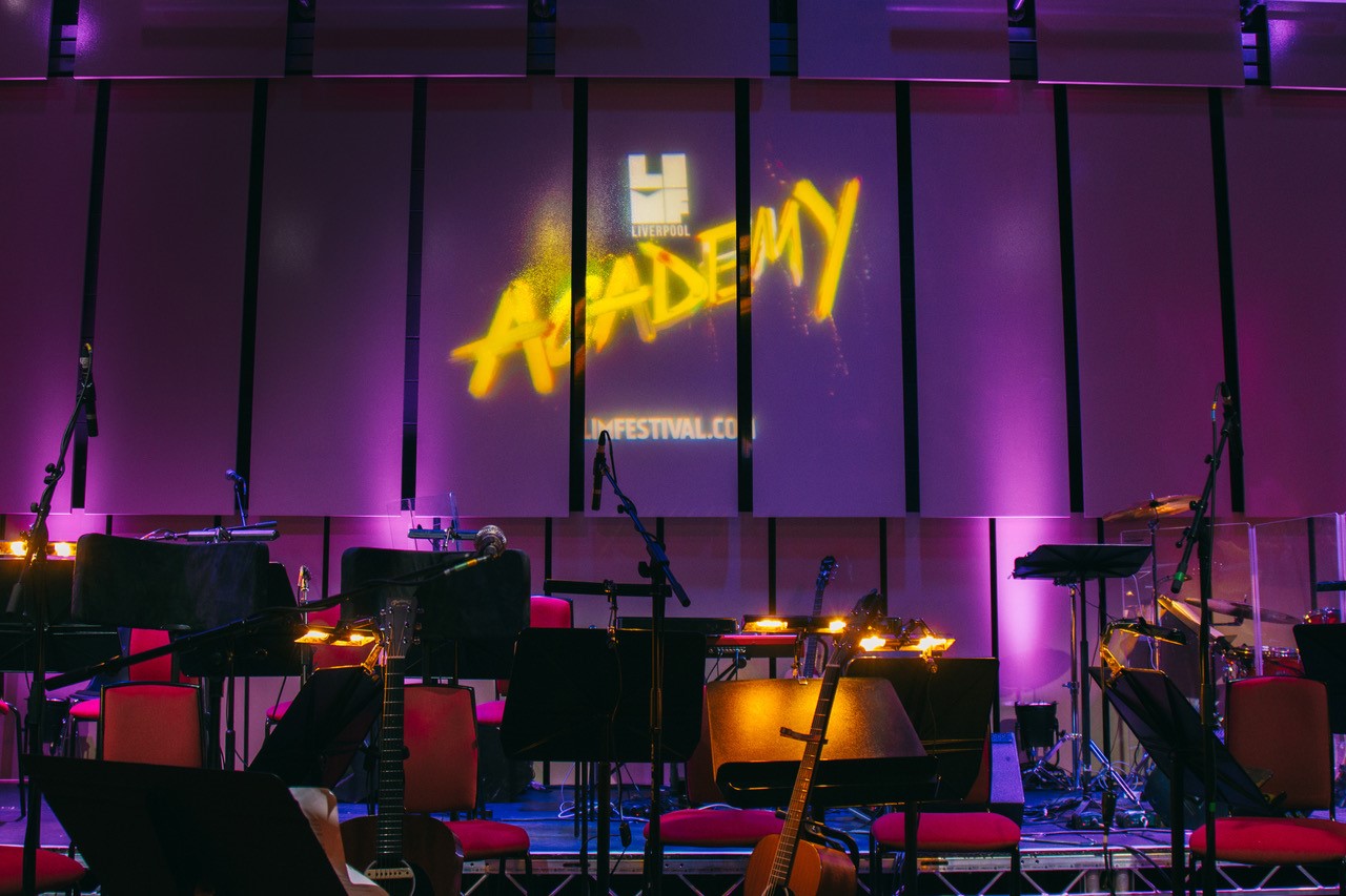 Empty stage with LIMF Academy branding illuminated on the wall