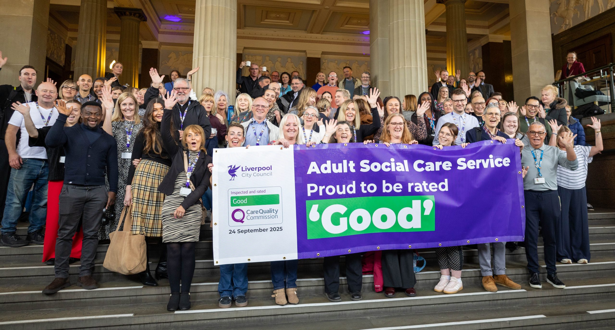 Adult Social Care Staff cheering holding holding banner which says 'Adult Social Care Services - Proud to be rate 'Good'. The sign is purple and the 'good' is in green.